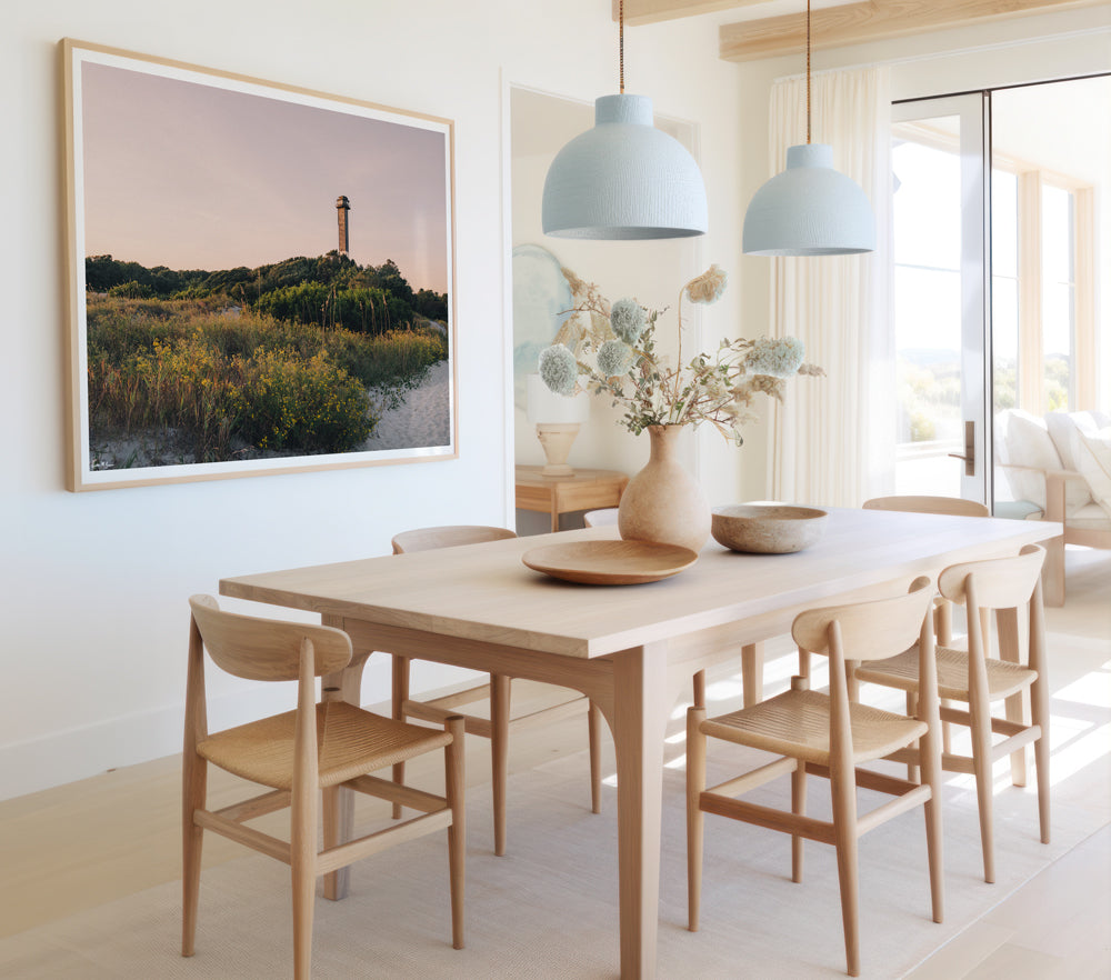 Framed photograph of Sullivan's Island lighthouse and beach dunes with pastel sunset sky. Hung in coastal dining room. "Charleston Light" photographed by Kristen M. Brown, Samba to the Sea.