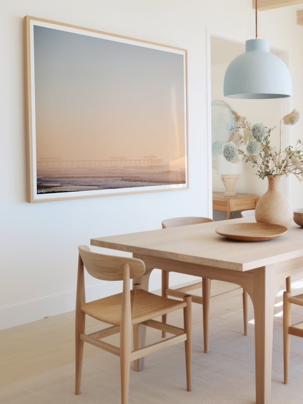 Framed photography of pastel sunrise in Charleston at Folly Beach pier. Hung in coastal dining room. "Folly Blushing" photographed by Kristen M. Brown, Samba to the Sea.