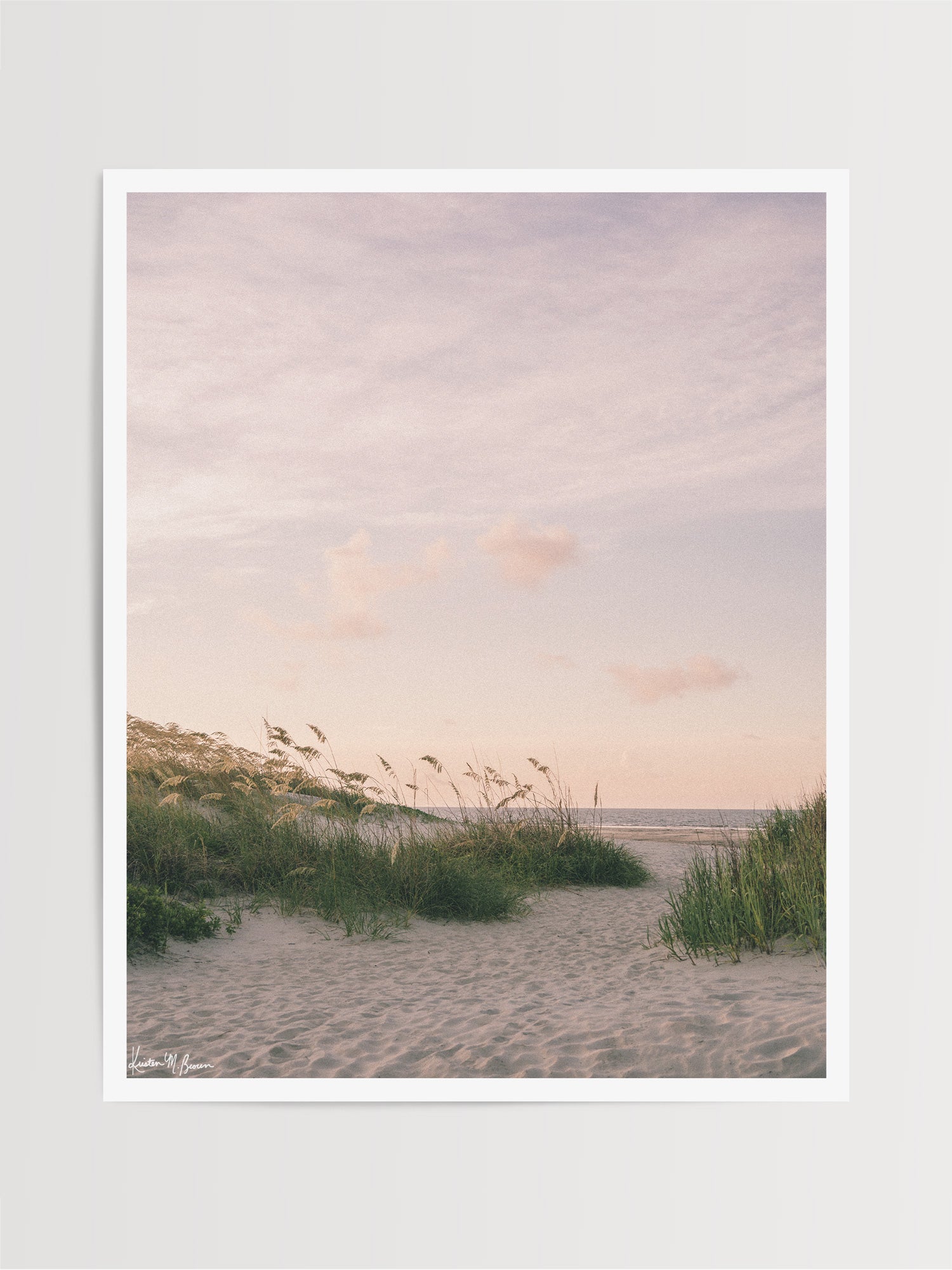 As the morning sun gently ushers in a new day, the coast unfolds in a quiet symphony of soft hues, rustling sea grasses, and an endless horizon. The golden sea oats dance softly in the ocean breeze, inviting you through the beach dunes towards the shoreline. Bring the tranquil rhythm of the ocean and the soothing warmth of a coastal morning into your everyday space with "Sea Oats and Sunrise" photography print.