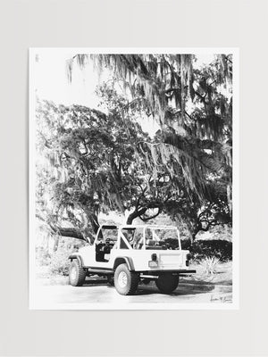 Black & White vintage white CJ parked under Oak trees dripping with Spanish Moss in Savannah, Georgia. Photographed by Kristen M. Brown of Samba to the Sea for The Sunset Shop.