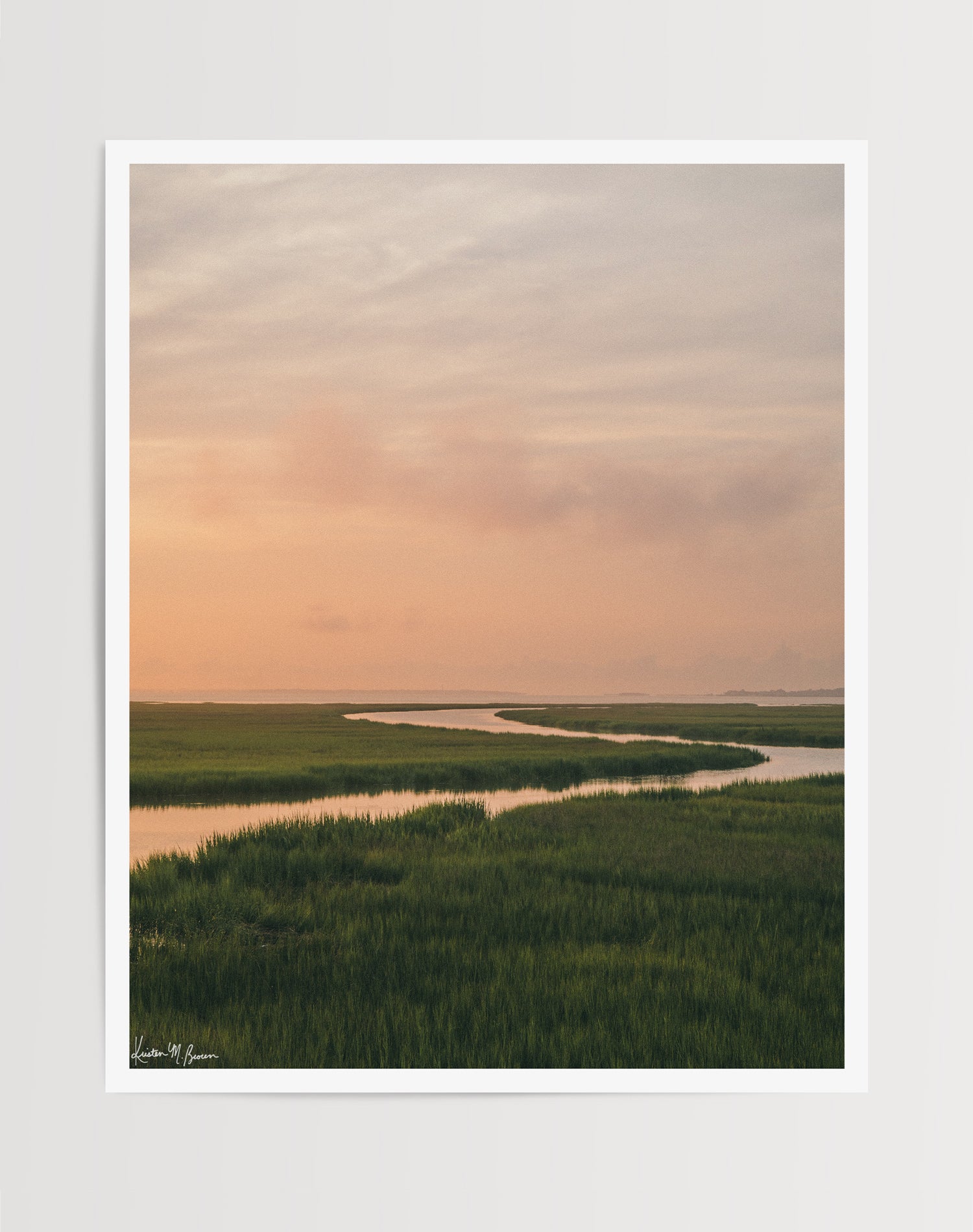 A scenic landscape photograph print of a winding creek flowing through the marsh during sunrise, with the soft peach and pink clouds in the sky above and reflecting in the waters. "Tidal Glow" fine art photography print photographed by Kristen M. Brown, Samba to the Sea.
