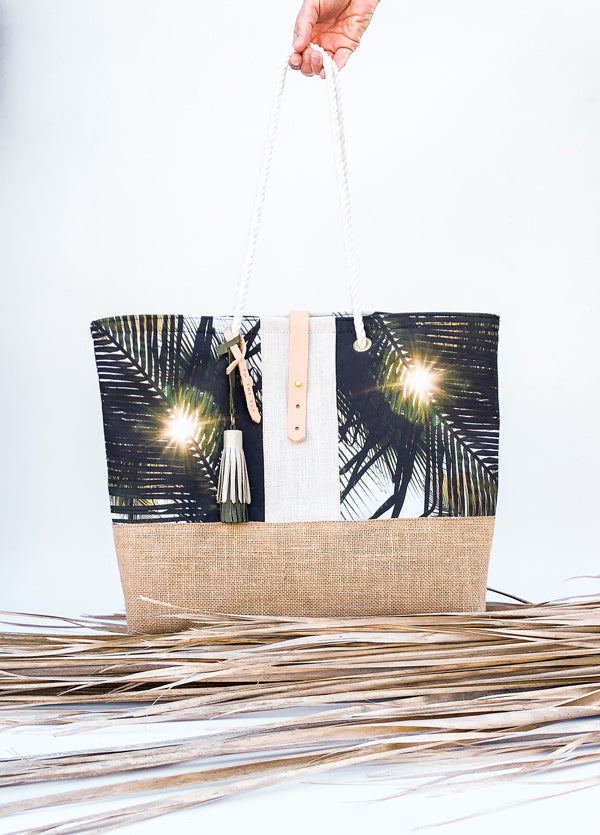 "Dreaming Under A Palm Tree" beach bag is the perfect bag to help you bring a piece of your tropical happy place with you, no matter where you may live. Palm tree print beach bag with leather tassels and cotton sailor rope. Chapman at Sea x Samba to the Sea collaboration.