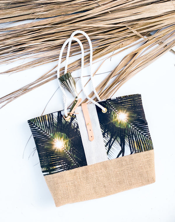 "Dreaming Under A Palm Tree" beach bag is the perfect bag to help you bring a piece of your tropical happy place with you, no matter where you may live. Palm tree print beach bag with leather tassels and cotton sailor rope. Chapman at Sea x Samba to the Sea collaboration.