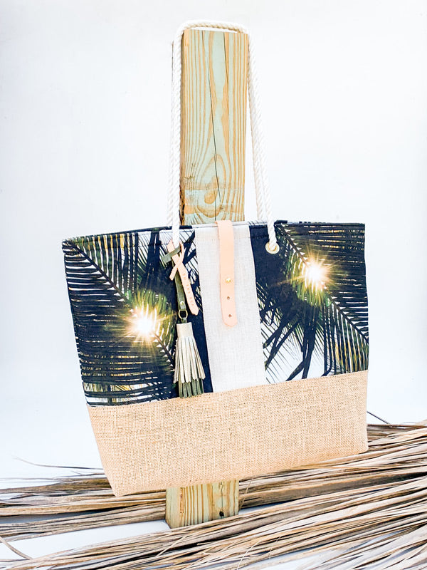 "Dreaming Under A Palm Tree" beach bag is the perfect bag to help you bring a piece of your tropical happy place with you, no matter where you may live. Palm tree print beach bag with leather tassels and cotton sailor rope. Chapman at Sea x Samba to the Sea collaboration.