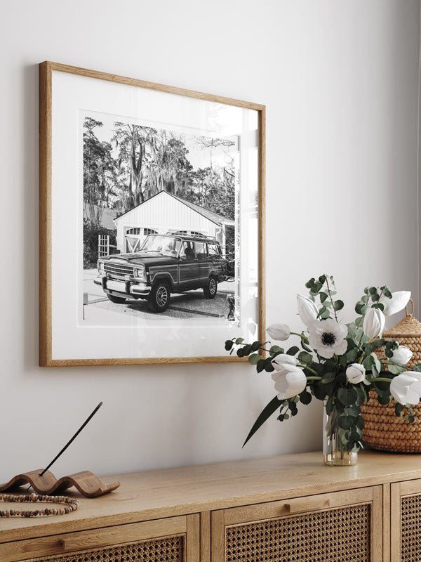 Black and White Jeep Wagoneer photo print wall art hanging above beautiful cane console. Welcome back to that amazing family vacation roadtrip, all from the comfort of your smart home...wherever home may be with this B&W photo print "Lowcountry Wagoneer".
