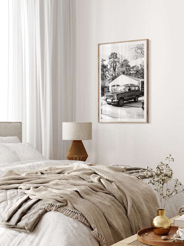 Jeep Wagoneer black and white wall art in neutral bedroom with caning furniture. Welcome back to that amazing family vacation roadtrip, all from the comfort of your smart home...wherever home may be with this B&W photo print "Lowcountry Wagoneer".
