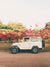 "Blooming and Cruising" photo print of vintage Toyota FJ40 Land Cruiser racked up with surfboards among vibrantly blooming Bougainvillea flowers in Costa Rica. Photographed by Costa Rica photographer Kristen M. Brown of Samba to the Sea for The Sunset Shop.