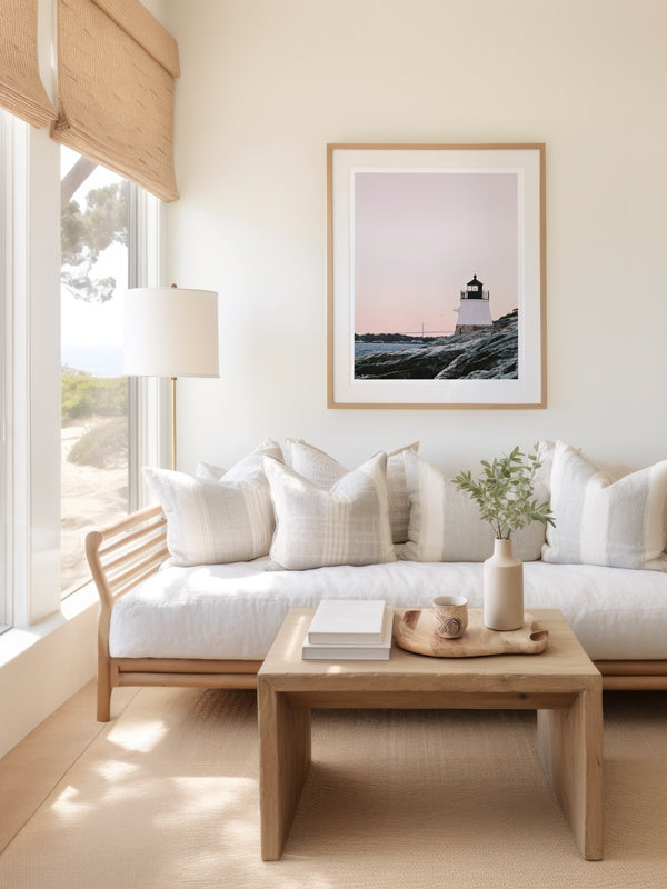 "Castle Hill en Rosé" photo print of the Castle Hill lighthouse in Newport, Rhode Island with a dreamy pastel pink sunrise sky and the Clairborne Pell Newport Bridge in the background hanging in a serene coastal living room. Photographed by Kristen M. Brown of Samba to the Sea for The Sunset Shop.