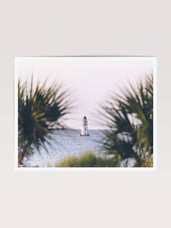 She's that beacon, the first thing you see as you cross over the bridge to Tybee Island. And she's the last thing on Tybee you say goodbye to once you're headed home from your summer beach vacation. She evokes all those feelings of Lowcountry coastal living. She is the petite Cockspur Lighthouse. ⠀ Cockspur Lighthouse during golden hour on Tybee Island, GA. "Cockspur" photographed by Kristen M. Brown of Samba to the Sea for The Sunset Shop.