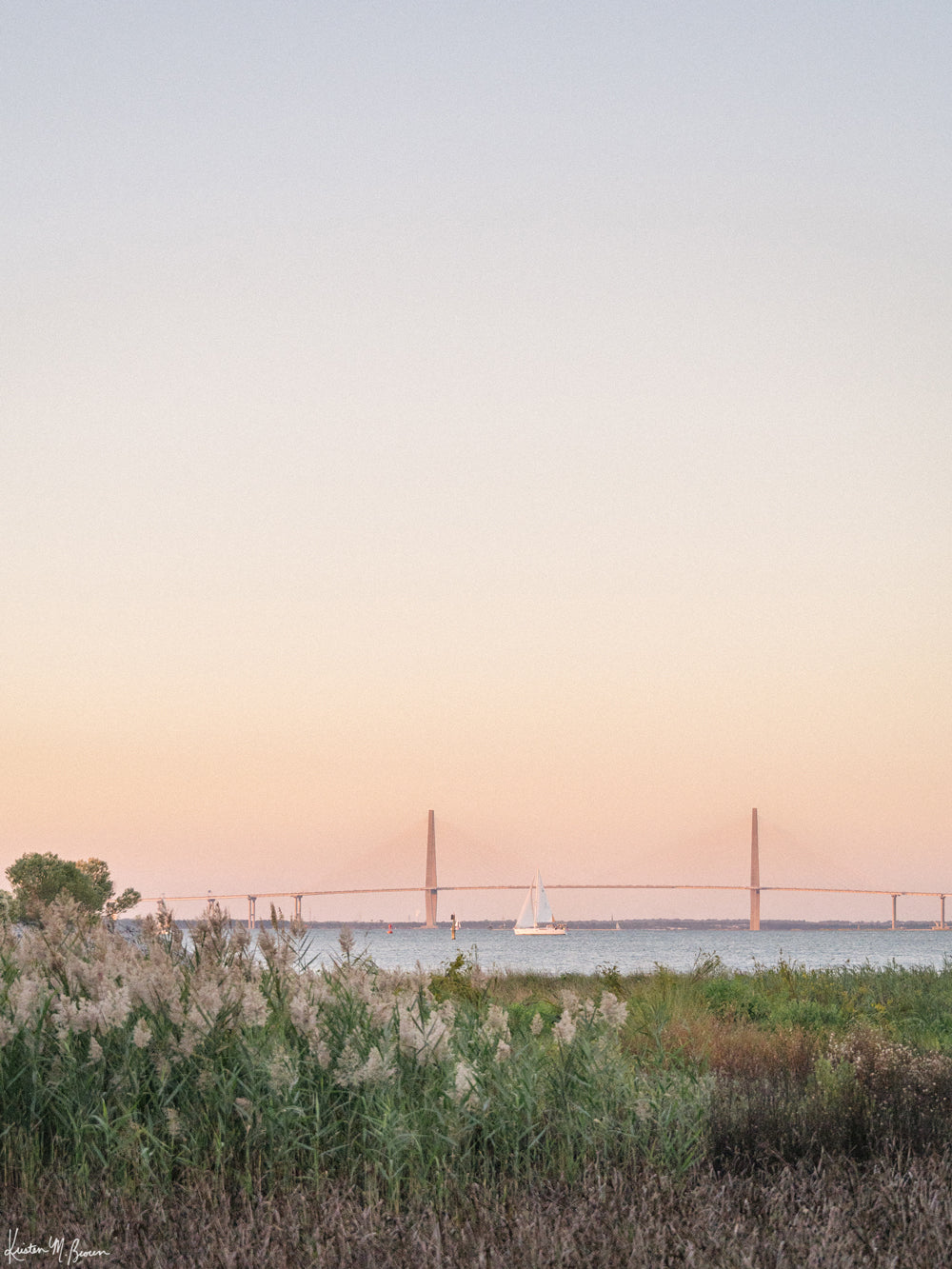 Photography of sailboat sailing at sunset in Charleston Harbor with Ravenel Bridge. "Harbor Sunset Sail" photographed by Kristen M. Brown, Samba to the Sea.