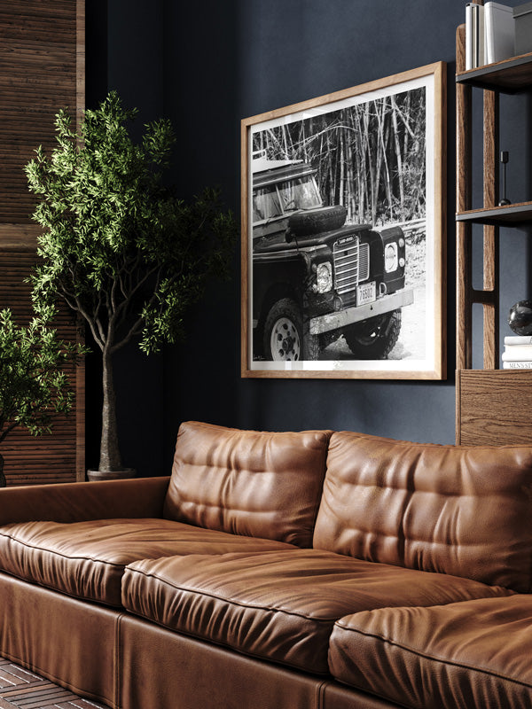 Vintage Land Rover black and white wall art in man cave library with dark walls and leather couch. Vintage car art by Kristen M. Brown of Samba to the Sea for The Sunset Shop.