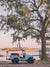  "Lowcountry Cruising" photo print of perfectly parked vintage Toyota FJ40 Land Cruiser with surfboards under a majestic Oak Tree along the marsh in Savannah, Georgia. Photographed by Kristen M. Brown of Samba to the Sea.