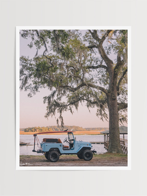  "Lowcountry Cruising" photo print of perfectly parked vintage Toyota FJ40 Land Cruiser with surfboards under a majestic Oak Tree along the marsh in Savannah, Georgia. Photographed by Kristen M. Brown of Samba to the Sea.