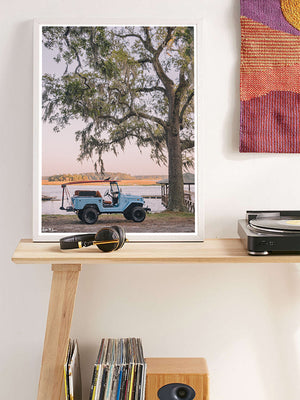 Vintage Toyota FJ40 photo print next to record player.  "Lowcountry Cruising" photo print of perfectly parked vintage Toyota FJ40 Land Cruiser with surfboards under a majestic Oak Tree along the marsh in Savannah, Georgia. Photographed by Kristen M. Brown of Samba to the Sea.