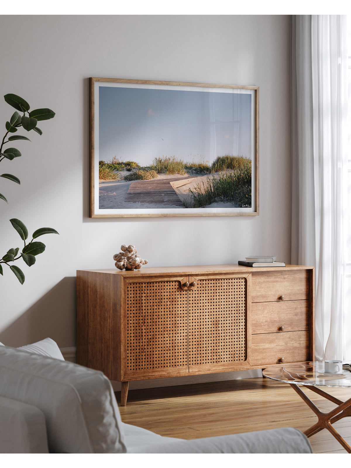 A framed landscape photograph of a wooden boardwalk path through beach dunes in Kiawah Island, SC. Through the wandering beach dunes and just over the boardwalk the shoreline awaits your morning stroll. Bring the tranquil rhythm of rolling beach dines and the soothing warmth of a coastal morning into your everyday space with "Morning Drift". Kiawah beac photo print by Kristen M. Brown of Samba to the Sea for The Sunset Shop.