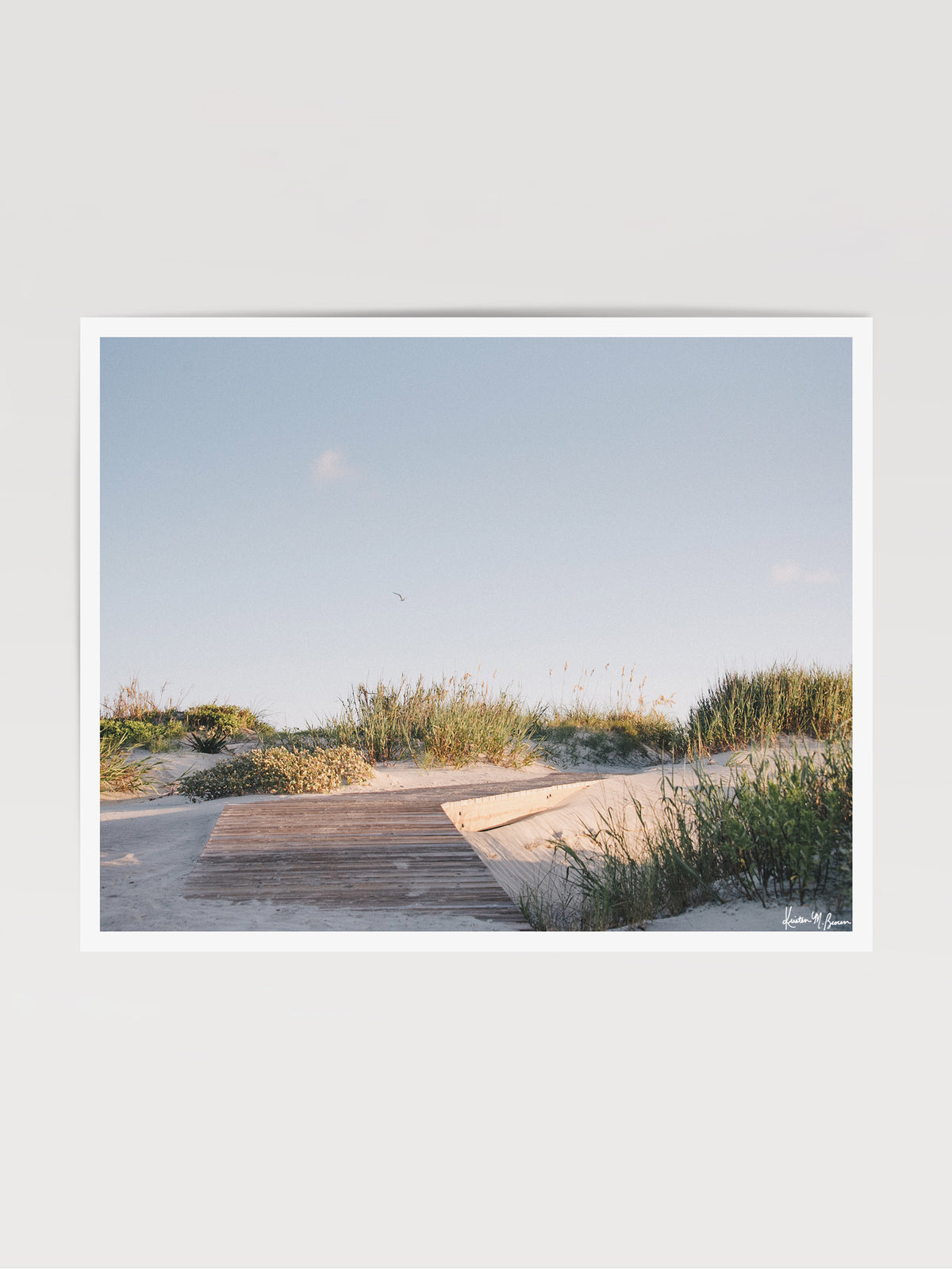 Through the wandering beach dunes and just over the boardwalk the shoreline awaits your morning stroll. Bring the tranquil rhythm of rolling beach dines and the soothing warmth of a coastal morning into your everyday space with "Morning Drift". Kiawah beac photo print by Kristen M. Brown of Samba to the Sea for The Sunset Shop.