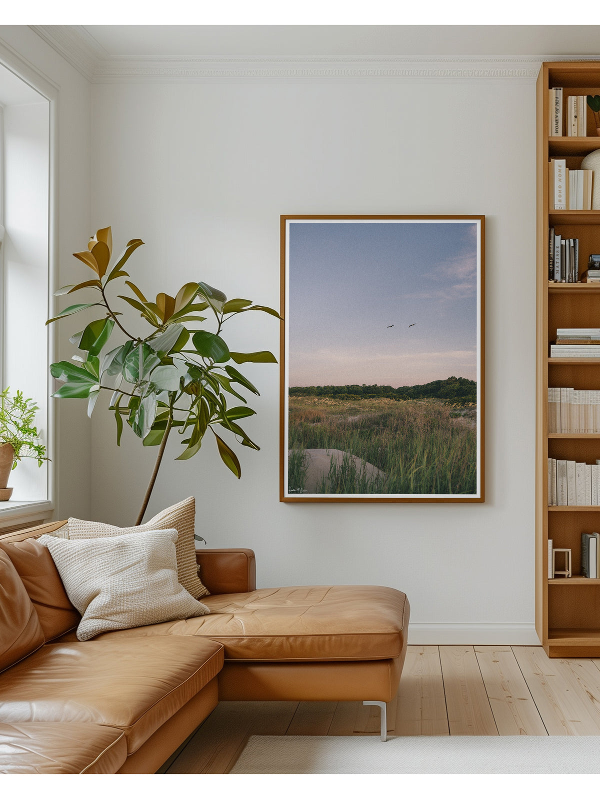 Framed Sullivan’s Island in Charleston, SC “Morning Flight” photo print. Across A wild expanse of dune grass and golden sea oats, two pelicans soar in effortless tandem against the gentle palette of dawn. In the background, lush maritime forest trees frame the horizon, while the soft, morning light washes over the dunes in calm, subtle tones. By Kristen M. Brown.