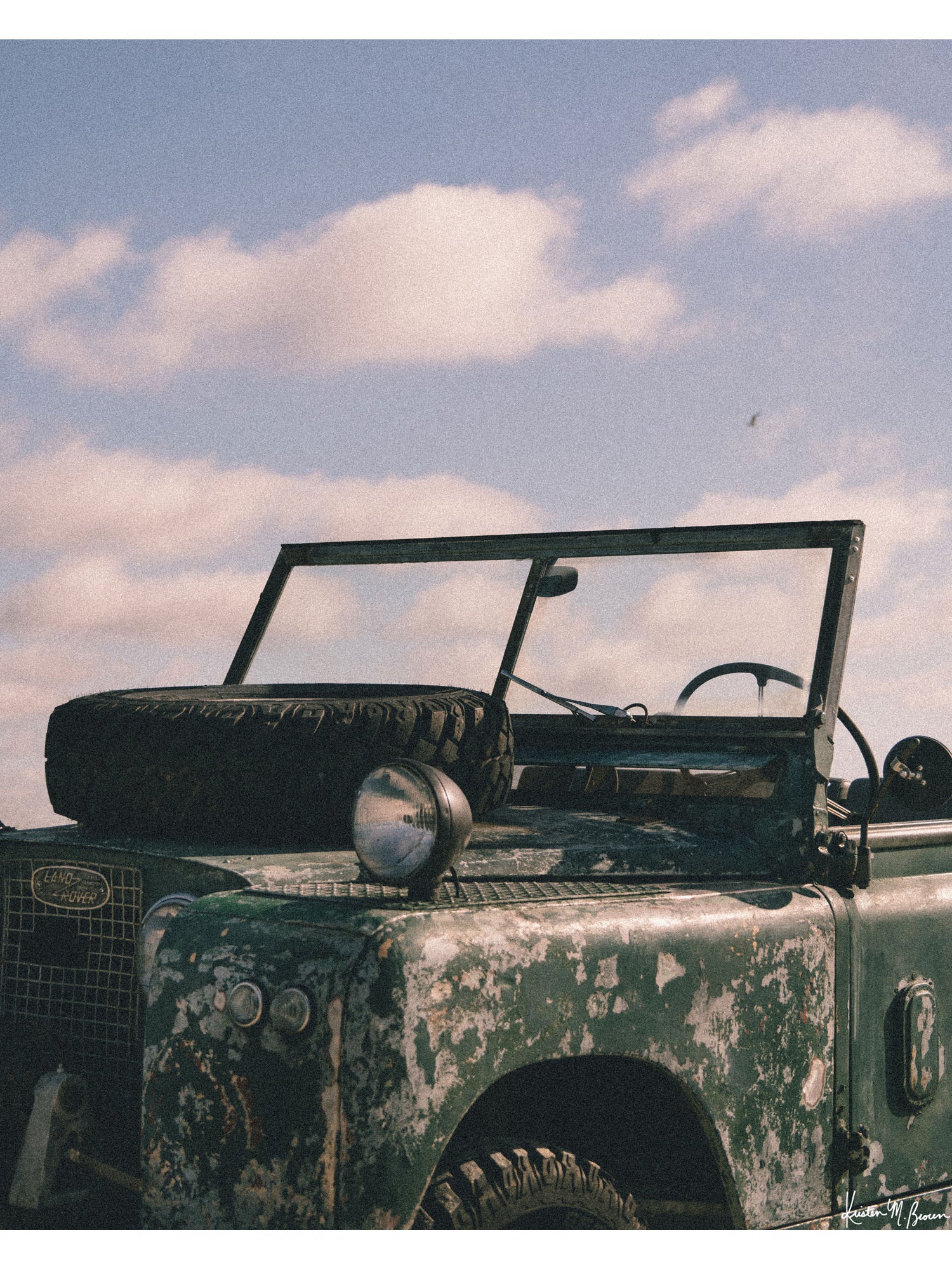 The raw, authentic character of this vintage 1963 Land Rover Series truck, with its iconic hood-mounted spare tire, open-top frame, and soft patina earned through years of adventure, "Patina" embodies the spirit of adventure.  Bring a touch of rugged soul, vintage heritage, and timeless  wanderlust into your space with "Patina", a print that turns rustic wear into pure artistry. Vintage Land Rover photo print by Kristen M. Brown of Samba to the Sea for The Sunset Shop.