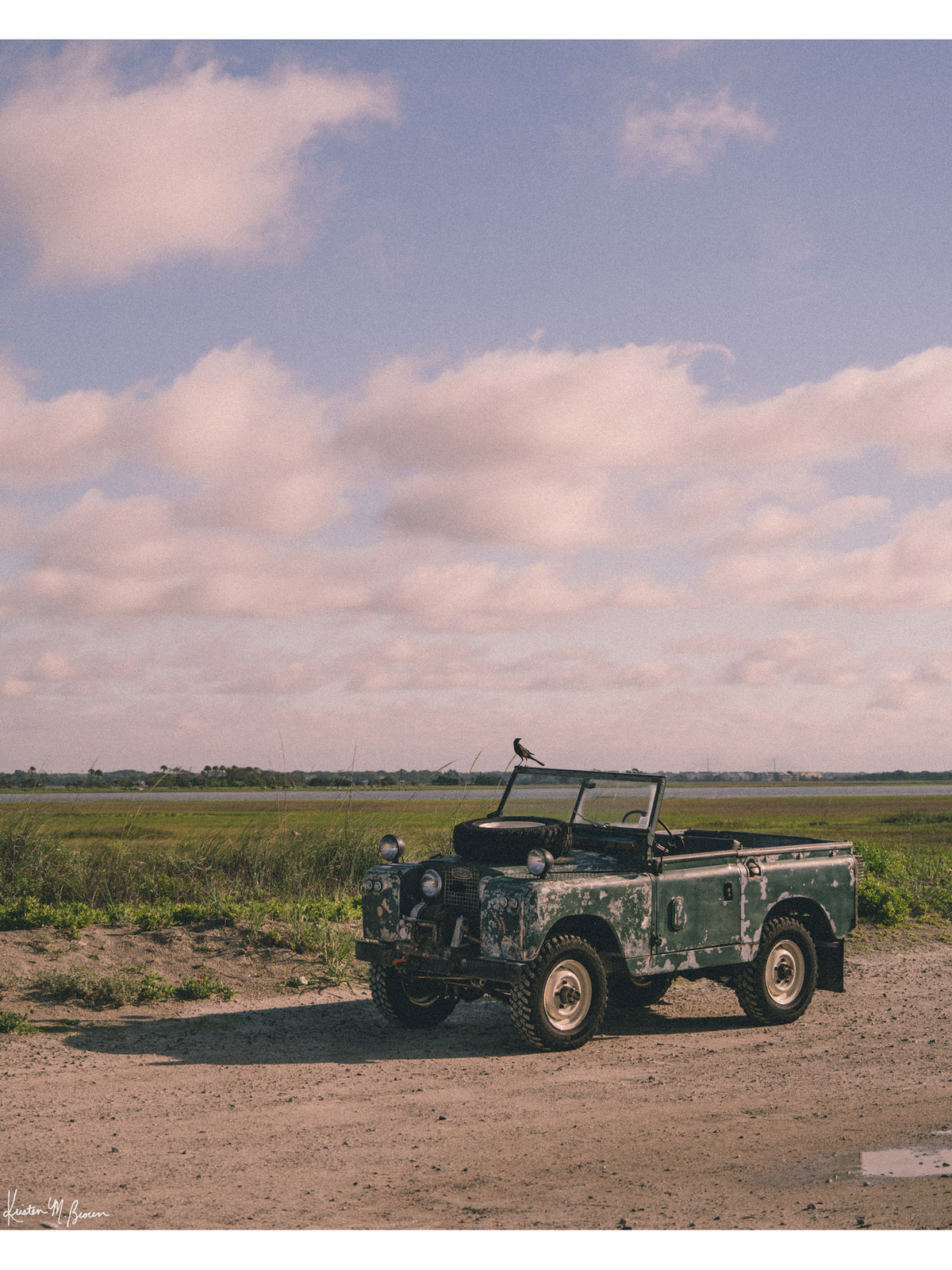Some stories aren’t written in books - they’re etched in weathered green paint, rusted edges, and decades of sand settled along coastal beach roads. Hop on in to "Perched Patrol" and bring home a piece of adventure with this classic 1963 Land Rover Series IIA truck photo print at the beach in Charleston, SC. Vintage Land Rover photo print by Kristen M. Brown of Samba to the Sea for The Sunset Shop.