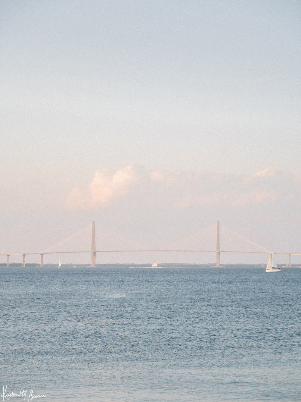 Photography of sailboats sailing in Charleston Harbor with Ravenel Bridge on a gorgeous afternoon under blue skies. “Saltwater Charmed” photographed by Kristen M. Brown, Samba to the Sea.