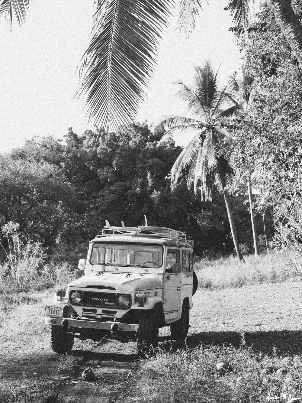 Down a dirt road in Costa Rica lies perfect waves just waiting for you to paddle out --  hop on in to this gorgeous, vintage Toyota Land Cruiser FJ40 and let&#39;s roll! &quot;Scenic Route&quot; black and white Land Cruiser photo print of surfboards racked on a vintage Toyota FJ40 photographed by Kristen M. Brown of Samba to the Sea @ The Sunset Shop.