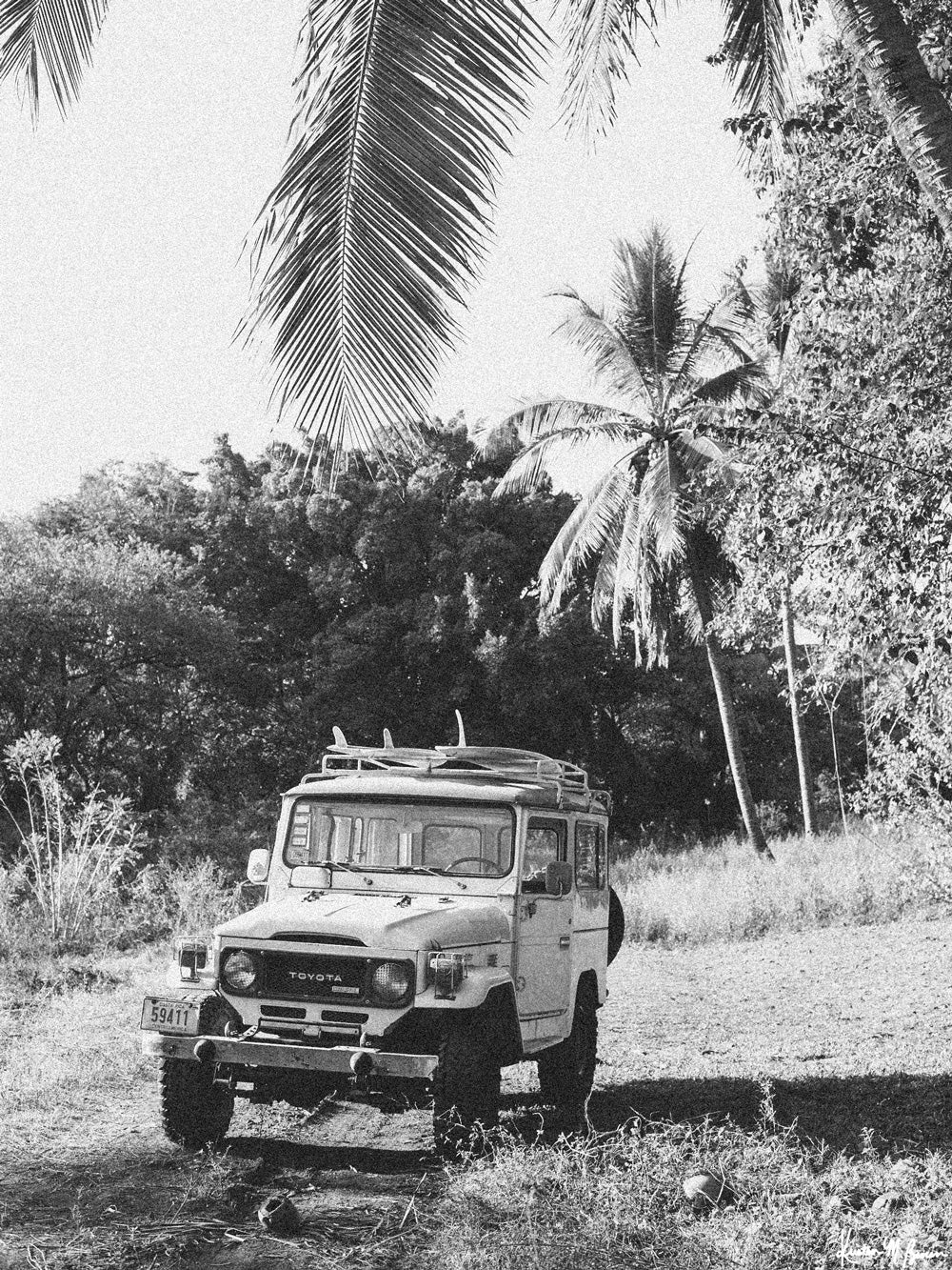 Down a dirt road in Costa Rica lies perfect waves just waiting for you to paddle out --  hop on in to this gorgeous, vintage Toyota Land Cruiser FJ40 and let's roll! "Scenic Route" black and white Land Cruiser photo print of surfboards racked on a vintage Toyota FJ40 photographed by Kristen M. Brown of Samba to the Sea @ The Sunset Shop.