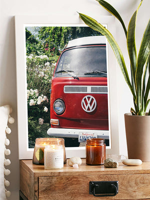 VW Bus photography print hanging in bedroom. Red VW Bus photo print in Southern California. “Sea Rose Bus” photo print of a beautiful vintage VW Bus parked next to white wea roses in California by Kristen M. Brown of Samba to the Sea for The Sunset Shop. 