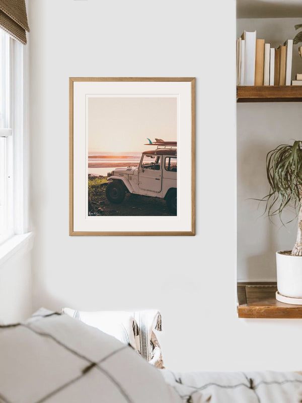 Surf photography vintage Land Cruiser wall art. "Seek and You Will Find" photo print of vintage Toyota FJ40 Land Cruiser racked up with surfboards parked at the beach in Costa Rica as the waves peel and the sun kissing the horizon turns everything golden. Photographed by Costa Rica photographer Kristen M. Brown of Samba to the Sea for The Sunset Shop.