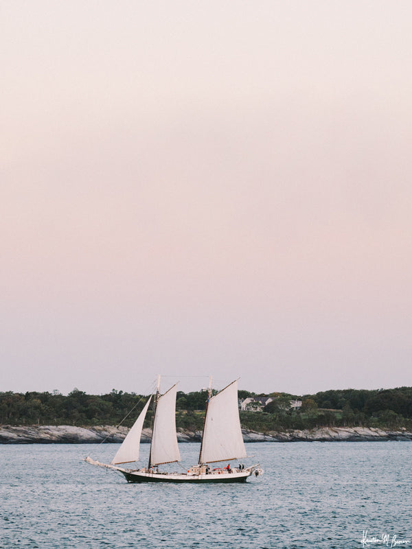 Her course is set straight out to the day breaking horizon and you&#39;re taking it all in -- the salty sweet sea aroma, the pastel pink sunrise sky, the refreshing chill in air, the twists and turns of the rocky shoreline, and the calming hum of the waves against your sailboat.   Welcome back to your coastal New England sailing daydream, all from the comfort of your home...wherever home may be with &quot;Set Sail at Sunrise&quot;.  Photographed by Kristen M. Brown of Samba to the Sea for The Sunset Shop.