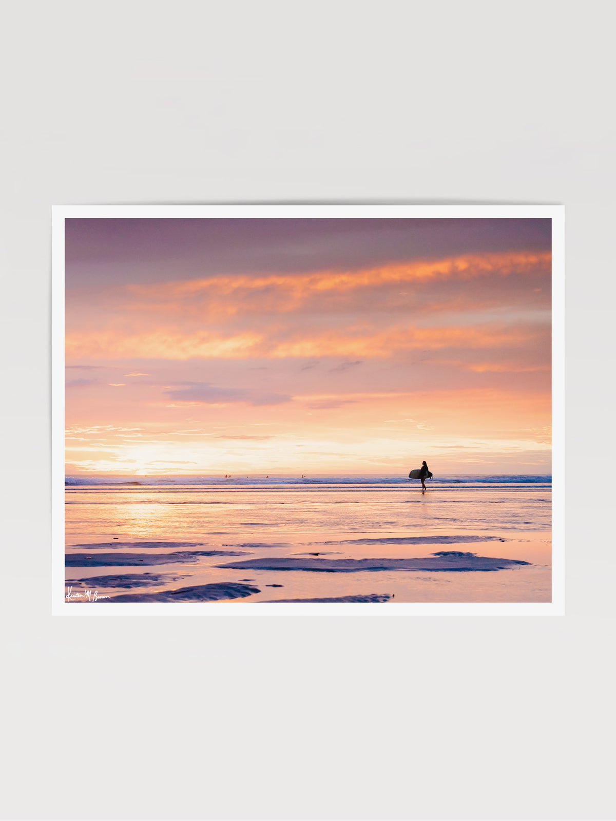 She&#39;s Magic sunset surfer print by Samba to the Sea at The Sunset Shop. Photo of a female surfer walking on the beach during a pastel pink sunset in Tamarindo, Costa Rica.