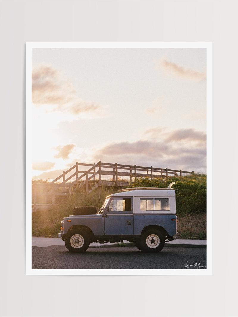 "Shore Rover" photo print of classic Land Rover series three with a single fin surfboard perfectly parked as the sun starts to rise over the Jersey Shore. Photographed by Kristen M. Brown of Samba to the Sea for The Sunset Shop.