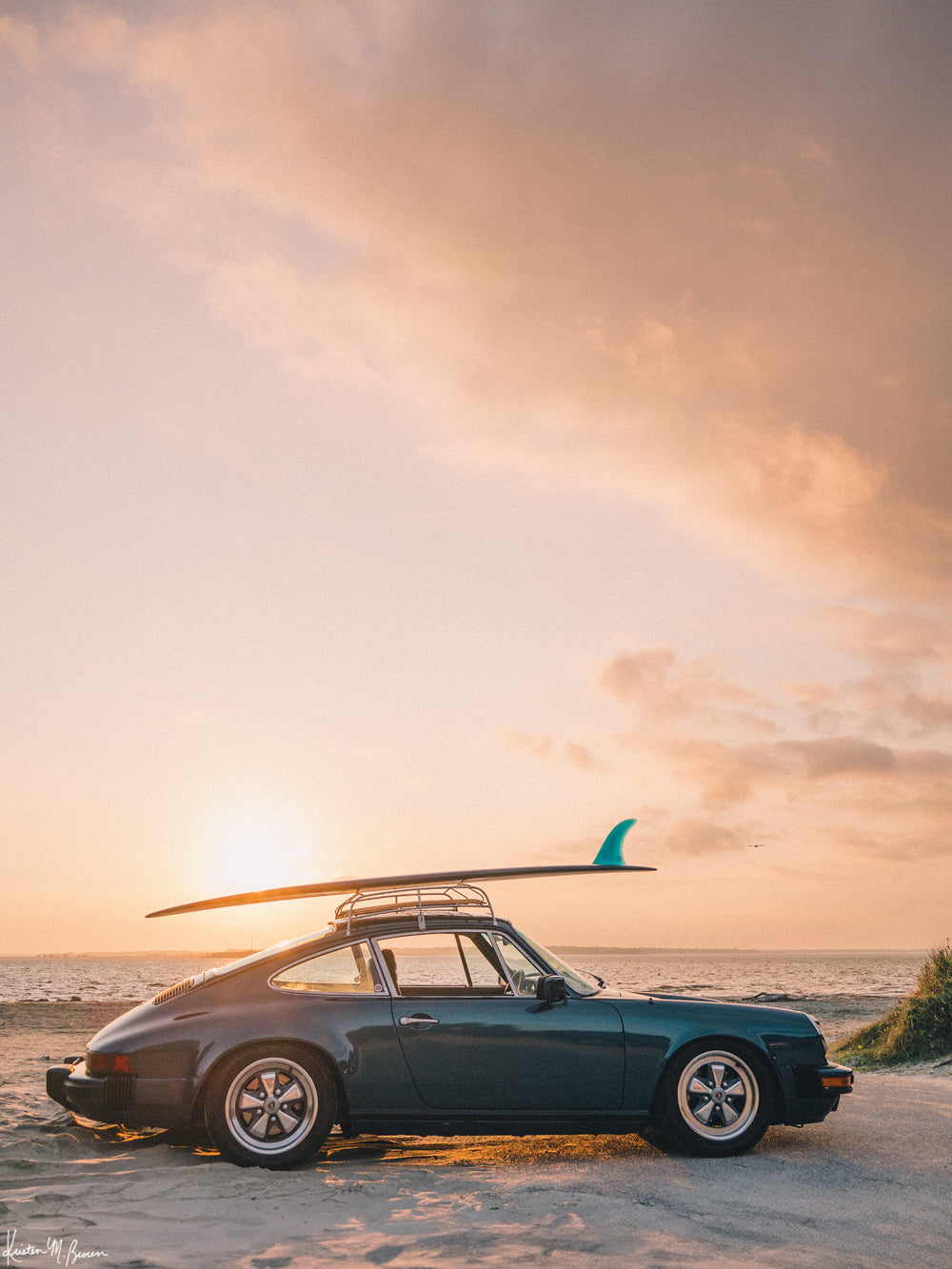 Photograph of vintage Porsche 911 parked at the beach with a classic single fin surfboard amidst a pastel pink sunset sky. "Single Fin Sunset Ride" photographed by Kristen M. Brown, Samba to the Sea.