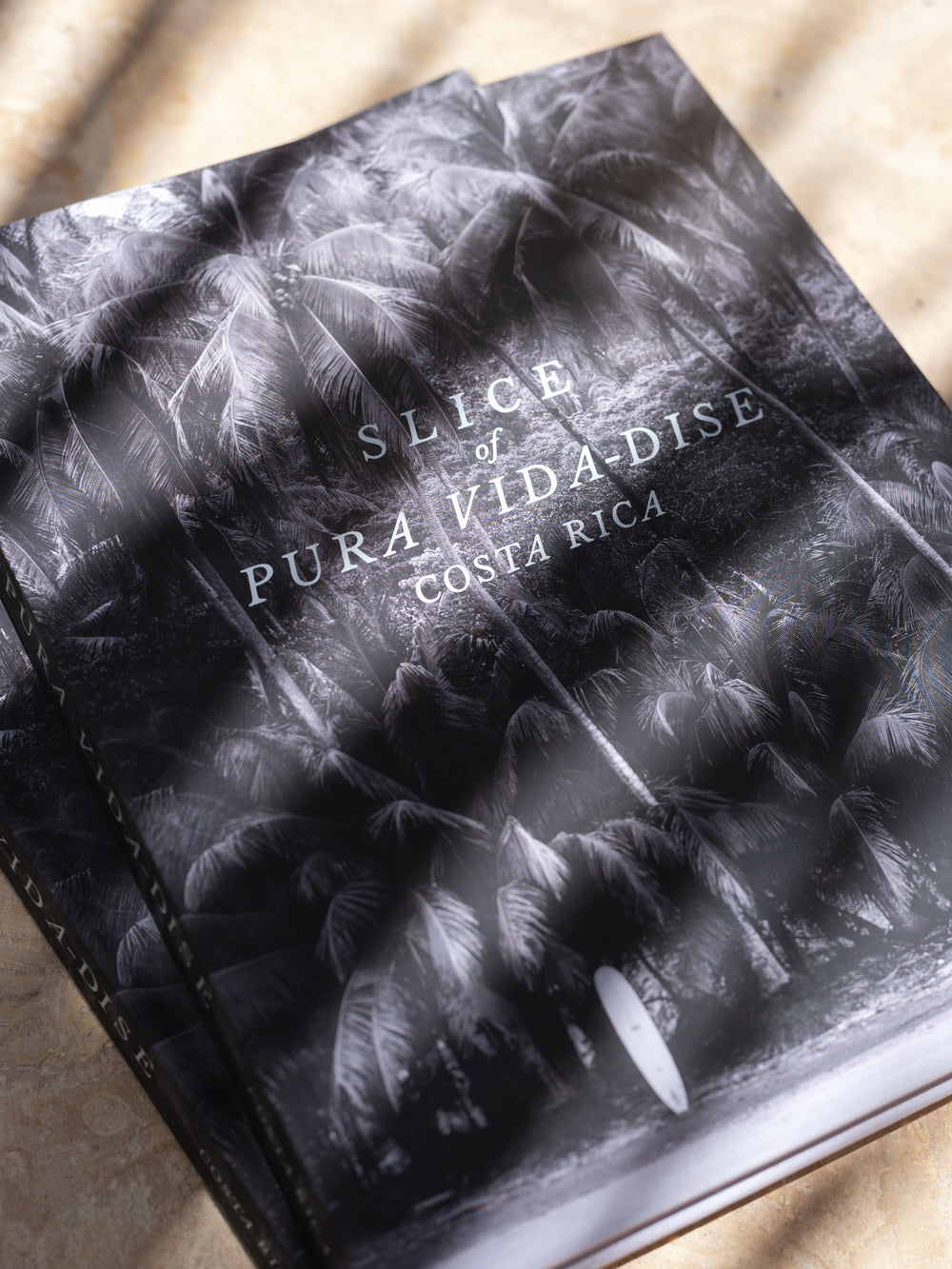 Costa Rica coffee table book. Dream away in this breathtaking photographic journey through Costa Rica's captivating coastline with this fine art Costa Rica coffee table book, Slice of Pura Vida-dise. Experience a part of the laid back “pura vida” way of life Costa Rica is infamous for with over 150 awe-inspiring images of pristine beaches, jaw dropping sunsets, and the alluring surf lifestyle. Photographed by Kristen M. Brown of Samba to the Sea.