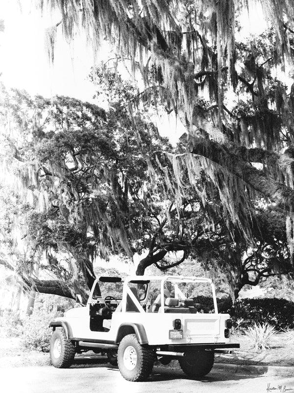 Black & White vintage white CJ parked under Oak trees dripping with Spanish Moss in Savannah, Georgia. Photographed by Kristen M. Brown of Samba to the Sea for The Sunset Shop.