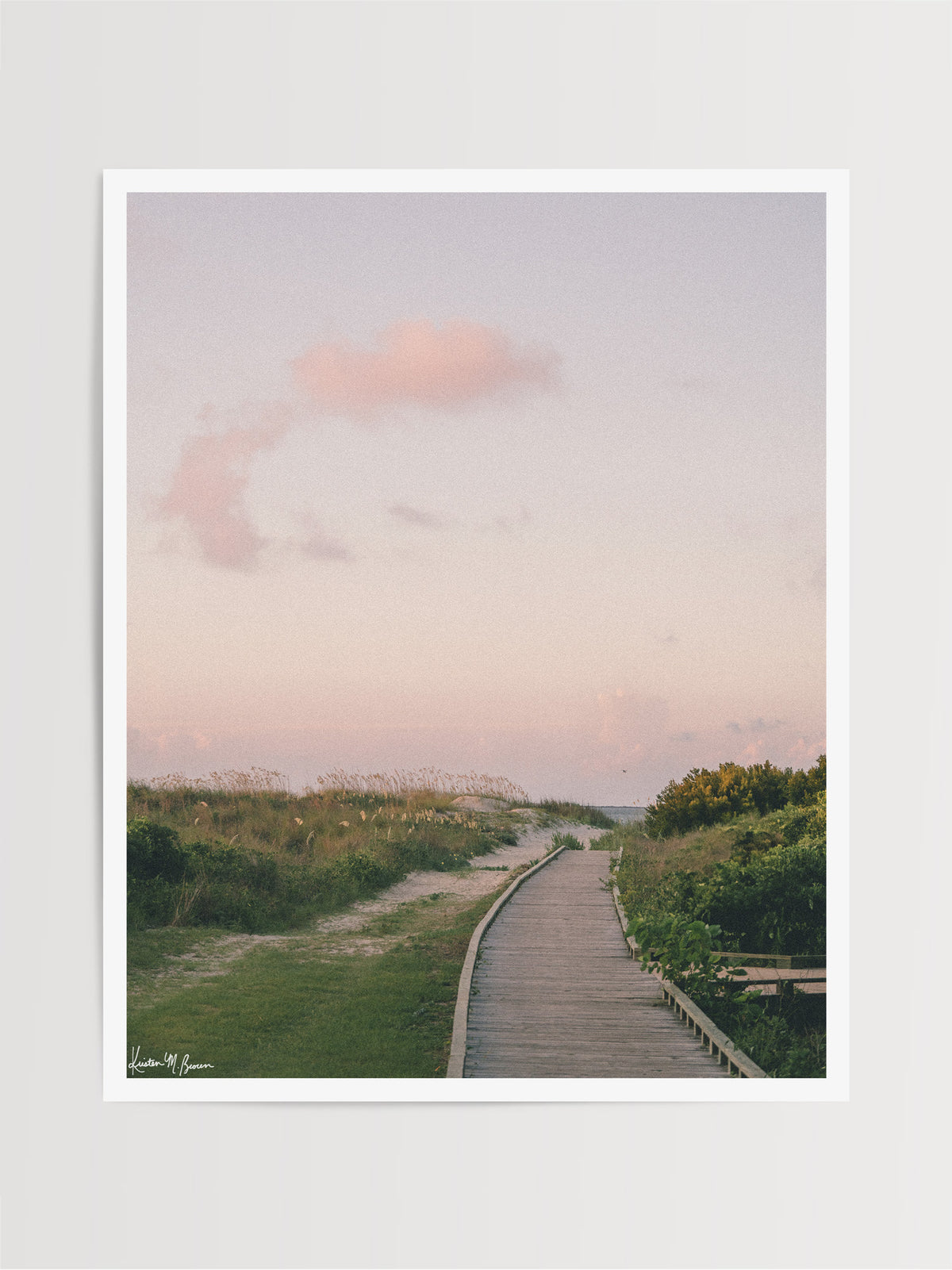 Before the world wakes up and when the shoreline belongs entirely to you, a pastel cloud drifts through a sky painted in soft blushes of pink, peach, and muted lavender, catching the very first light of dawn through the beach dunes and path boardwalk Station on Sullivan’s Island, SC. Bring home that feeling with "Station Sunrise". Photo print by Kristen M. Brown of Samba to the Sea for The Sunset Shop.