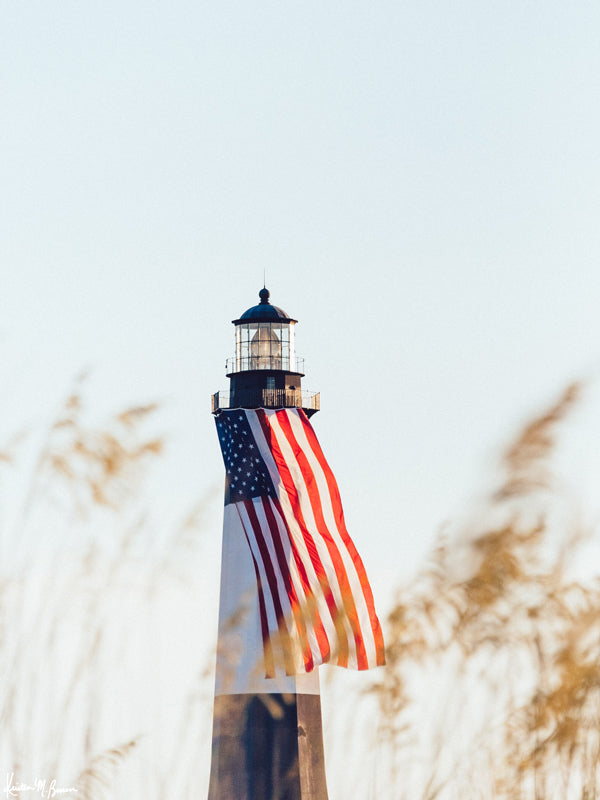 There she was, dancing in the sea breeze with the sea grass and shimmering in the late afternoon sun! Majestic American flag hanging from the Tybee Island Lighthouse in Tybee Island, GA. &quot;Sweet Liberty&quot; photographed by Kristen M. Brown, Samba to the Sea for The Sunset Shop.