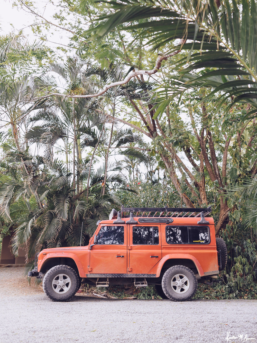 Because life is all about the magic in the detours and the beauty of taking time to explore bumpy, back road dirt roads in tropical paradise with a vibrant red Land Rover Defender just like this. &quot;Tropical Sleigh&quot; photographed by Kristen M. Brown, Samba to the Sea for The Sunset Shop.