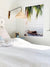 White coastal bedroom with tropical palm tree photo print. Surf shack and beach bungalow vibes. "Via Paradise" beach print by Kristen M. Brown of Samba to the Sea for The Sunset Shop.