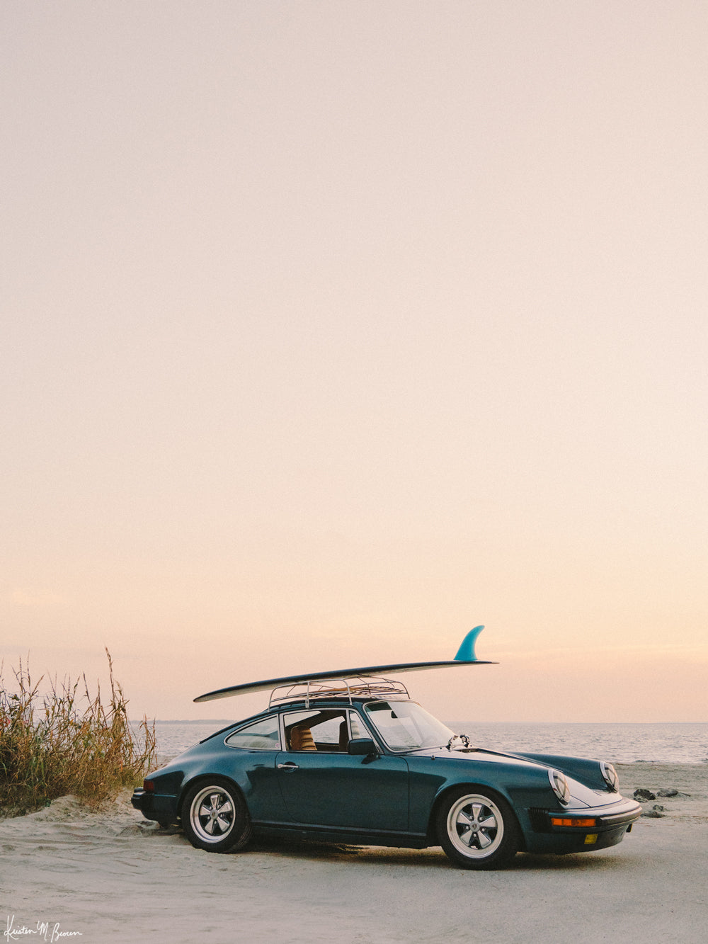 Photograph of vintage Porsche 911 parked at the beach with a classic single fin surfboard amidst a pastel pink sunset sky. "Single Fin Sunset Ride" photographed by Kristen M. Brown, Samba to the Sea.