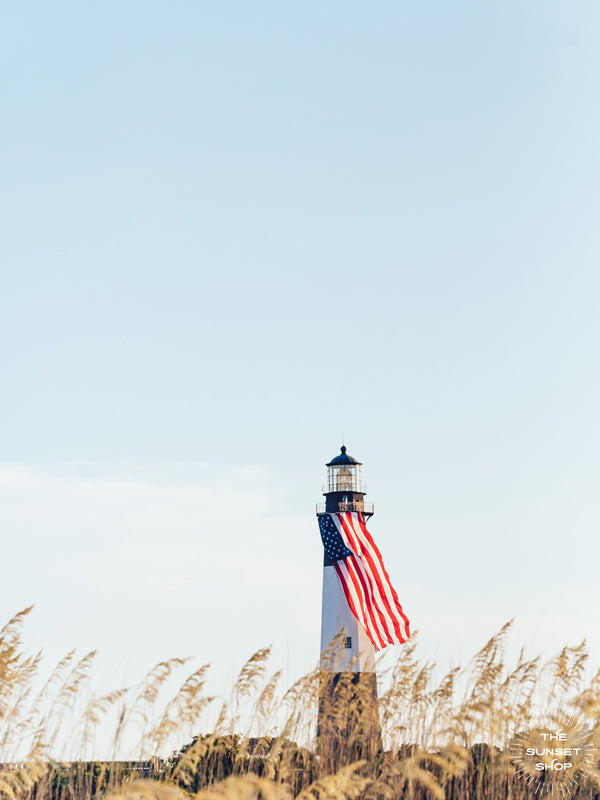 There she was, dancing in the sea breeze with the sea grass and shimmering in the late afternoon sun! Majestic American flag hanging from the Tybee Island Lighthouse in Tybee Island, GA. "American Beauty" photographed by Kristen M. Brown, Samba to the Sea for The Sunset Shop.