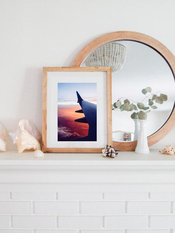 Because life was meant for good friends and adventures. Be inspired to go on your next adventure with this magical pink sunset from an airplane print "And So The Adventure Begins". Photographed by Kristen M. Brown, Samba to the Sea.  Coastal living framed sunset print shelfie on white fireplace mantle.