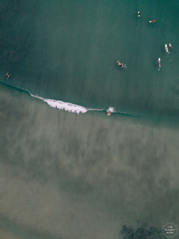 Aerial surfer wave print by Samba to the Sea at The Sunset Shop. Image is an aerial photo of surfer dropping in on a wave in Playa Avellanas, Costa Rica.