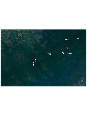 There's nothing quite like paddling out and sharing waves with your friends. Now that's your kind of board meeting! 🌊 Aerial image of surfers in ocean in Costa Rica by Samba to the Sea at The Sunset Shop.