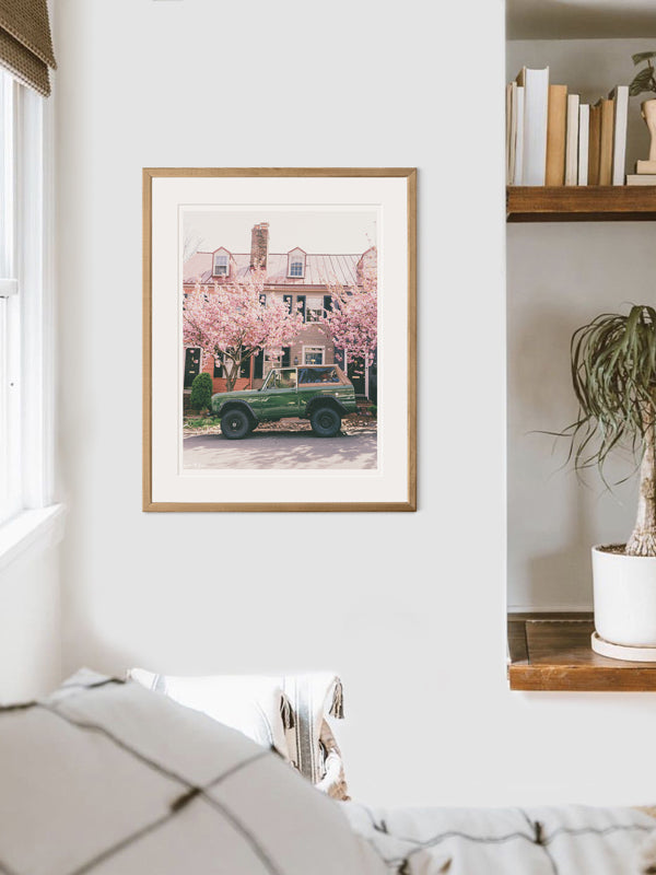 Vintage Ford Bronco wall art in bedroom. So what are you waiting for? Hop on in city slicker and let's take a spring road trip to the beach! Welcome back to your beach roadtrip daydreams, all from the comfort of your home...wherever that home may be with this photo print "Bronco Blossoms". Photographed by Kristen M. Brown of Samba to the Sea for The Sunset Shop.