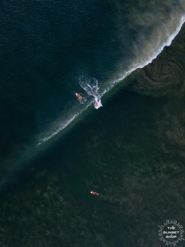Aerial surfer print by Samba to the Sea at The Sunset Shop. Image is an aerial photo of surfer dropping in on a wave in Tamarindo, Costa Rica.