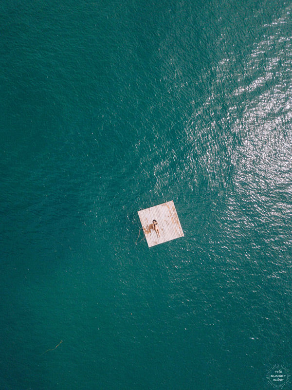 Woman laying on raft in the turquoise ocean Las Catalinas, Costa Rica. Photographed by Samba to the Sea for The Sunset Shop. 