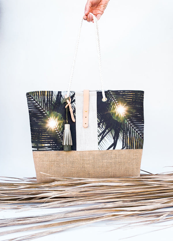 "Dreaming Under A Palm Tree" beach bag is the perfect bag to help you bring a piece of your tropical happy place with you, no matter where you may live. Palm tree print beach bag with leather tassels and cotton sailor rope. Chapman at Sea x Samba to the Sea collaboration. 