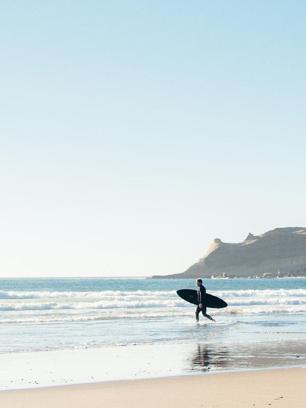 Surfer walking into the ocean in Pacific City, Oregon. Into the Blue surfer print by Kristen M. Brown, Samba to the Sea.