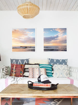 Boho chic living room with framed beach print. Beautiful pink rain and pastel sunset print. Anthropologie pillow, Urban Outfitters pillow, Target home decor, History of Surfing Book. Photographed by Samba to the Sea for The Sunset Shop.