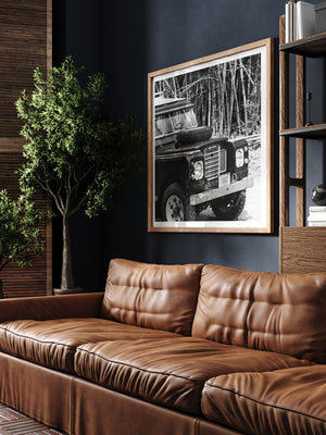 Vintage Land Rover black and white photo print man cave library with dark walls and leather couch. Welcome back to your adventure daydream, all from the comfort of your home...wherever home may be with "Landy Three". Black and white photo print of Land Rover Series 3 by Kristen M. Brown of Samba to the Sea for The Sunset Shop.